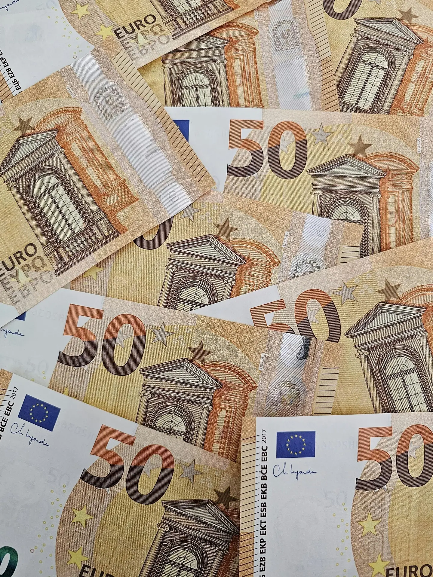 Close-up shot of a pile of 50 Euro banknotes, displaying intricate details and design.
