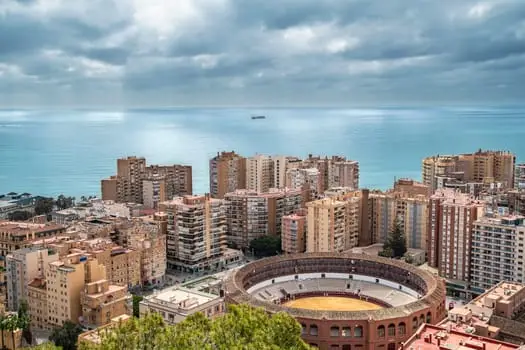 Aerial shot of Malaga's skyline featuring the bullring and sea horizon, perfect for travel themes.